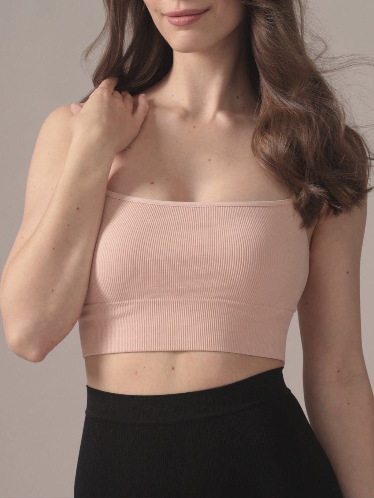 Woman wearing a light pink seamless bralette