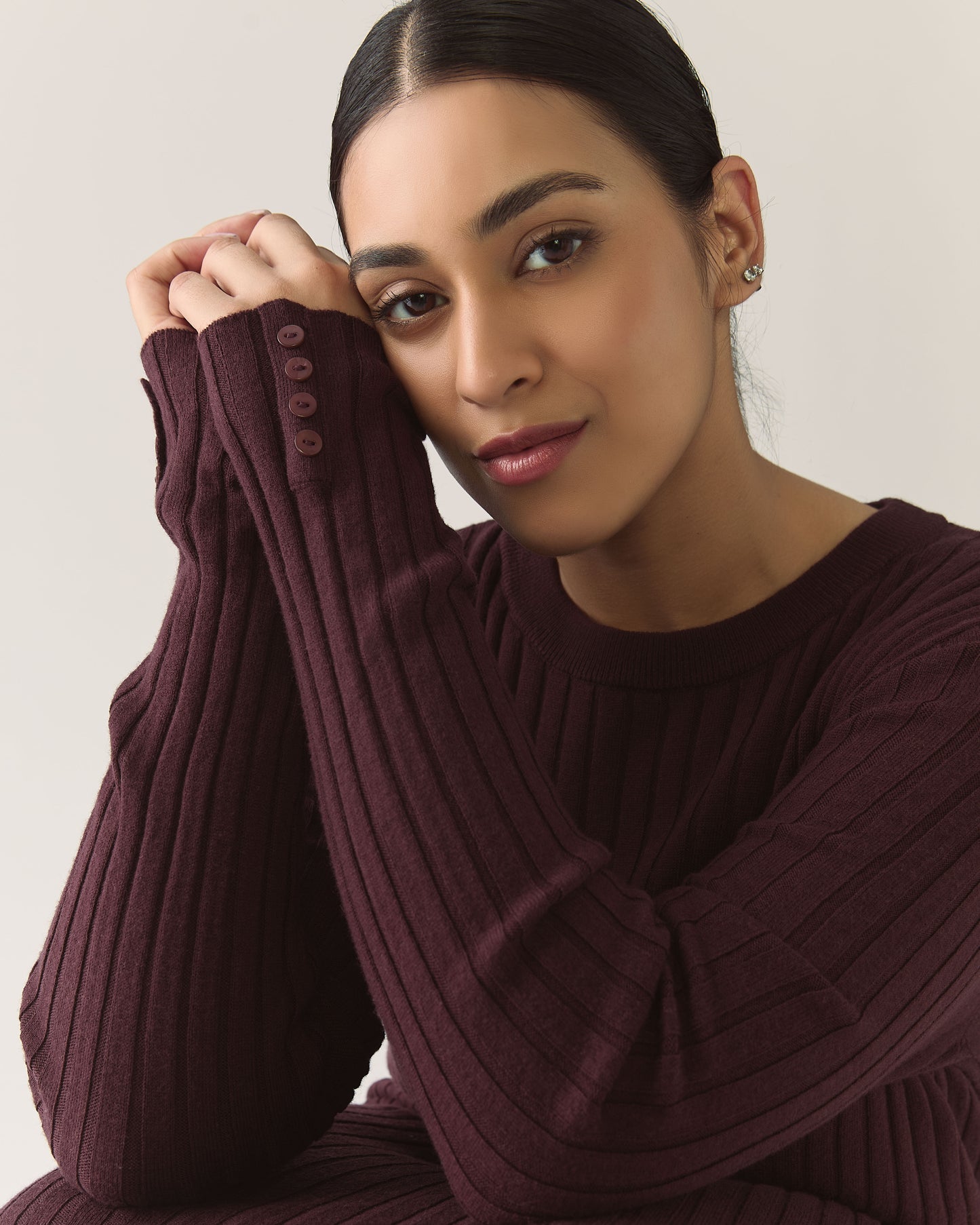 Woman wearing a burgundy plum ribbed sweater dress