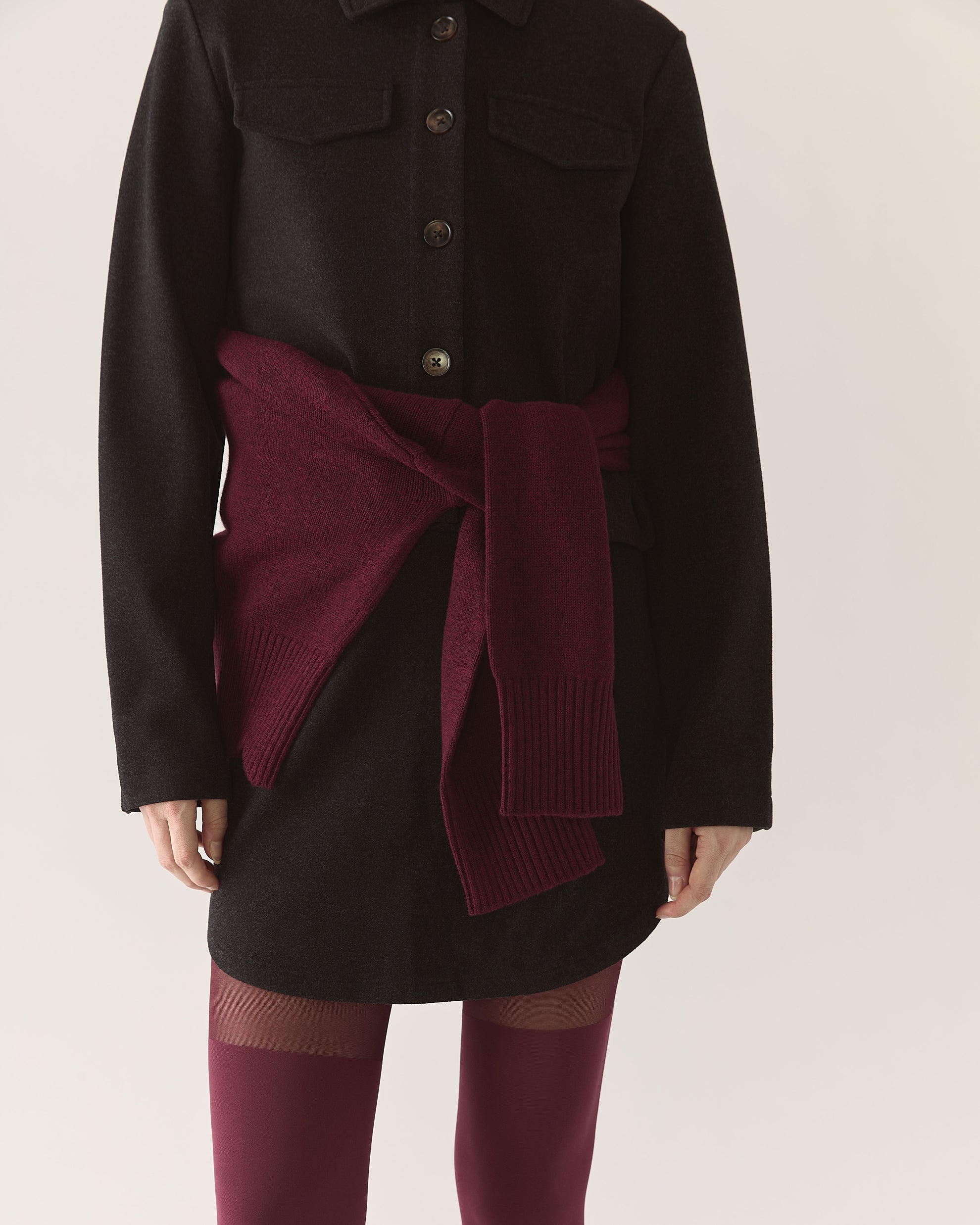 Charcoal coat with a burgundy sweater tied around the waist with Charcoal skirt